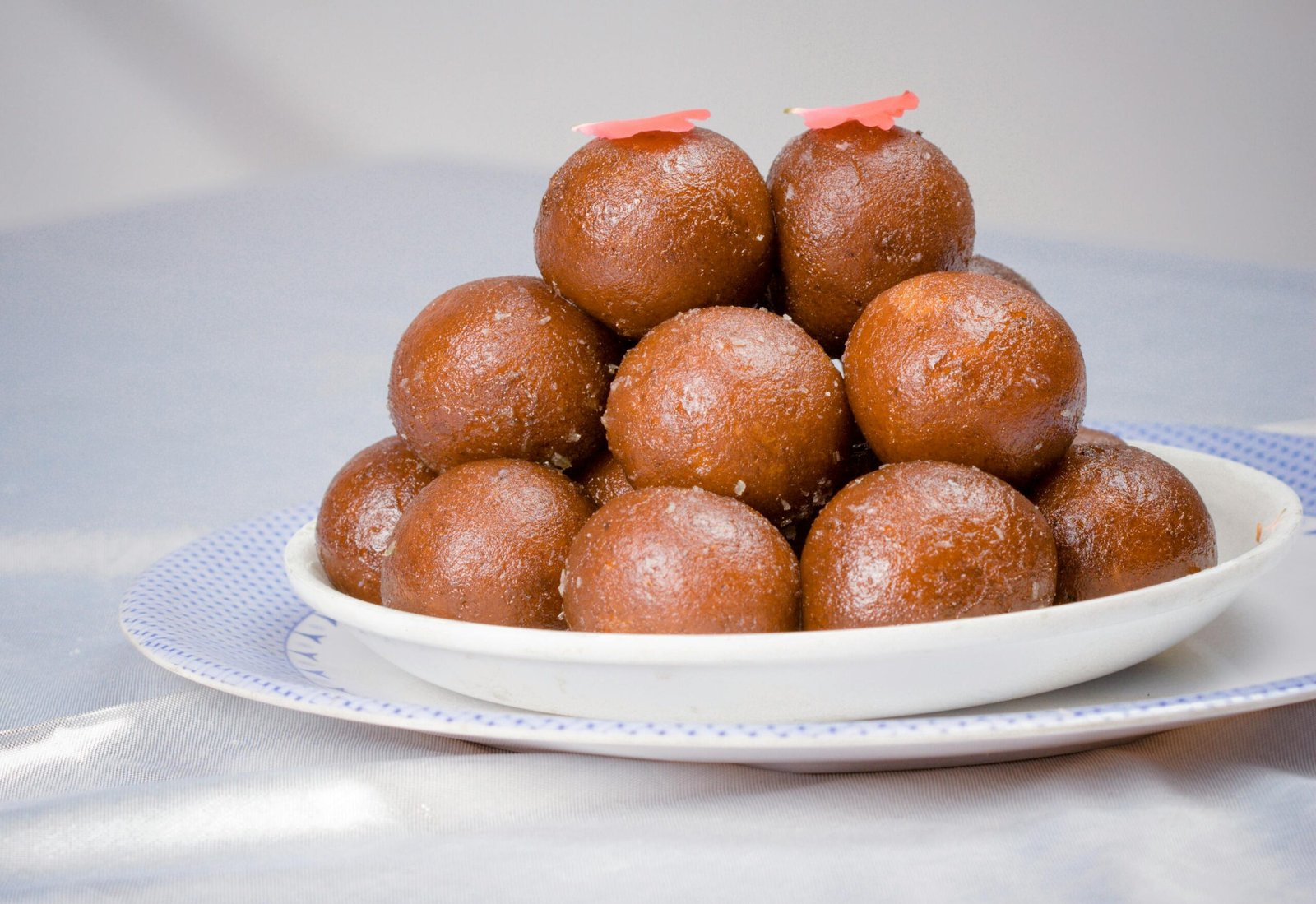 Close-up of a traditional Indian dessert, Gulab Jamun, served on a white plate.