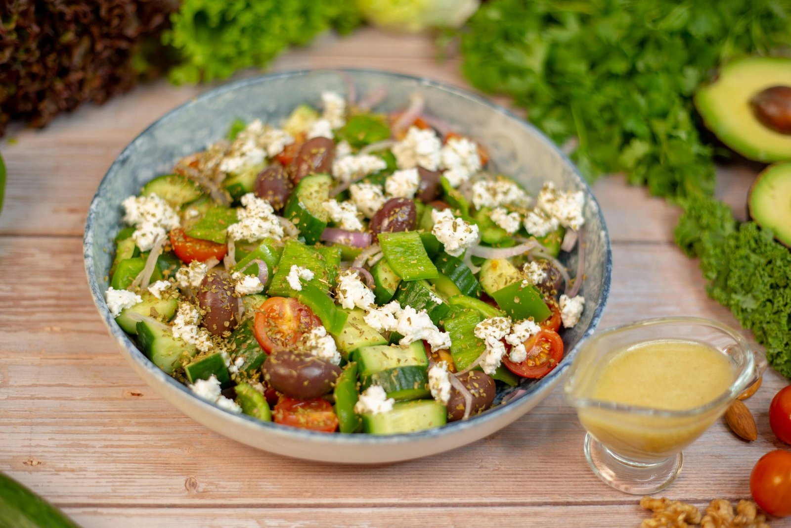 A salad with vegetables and dressing on a wooden table