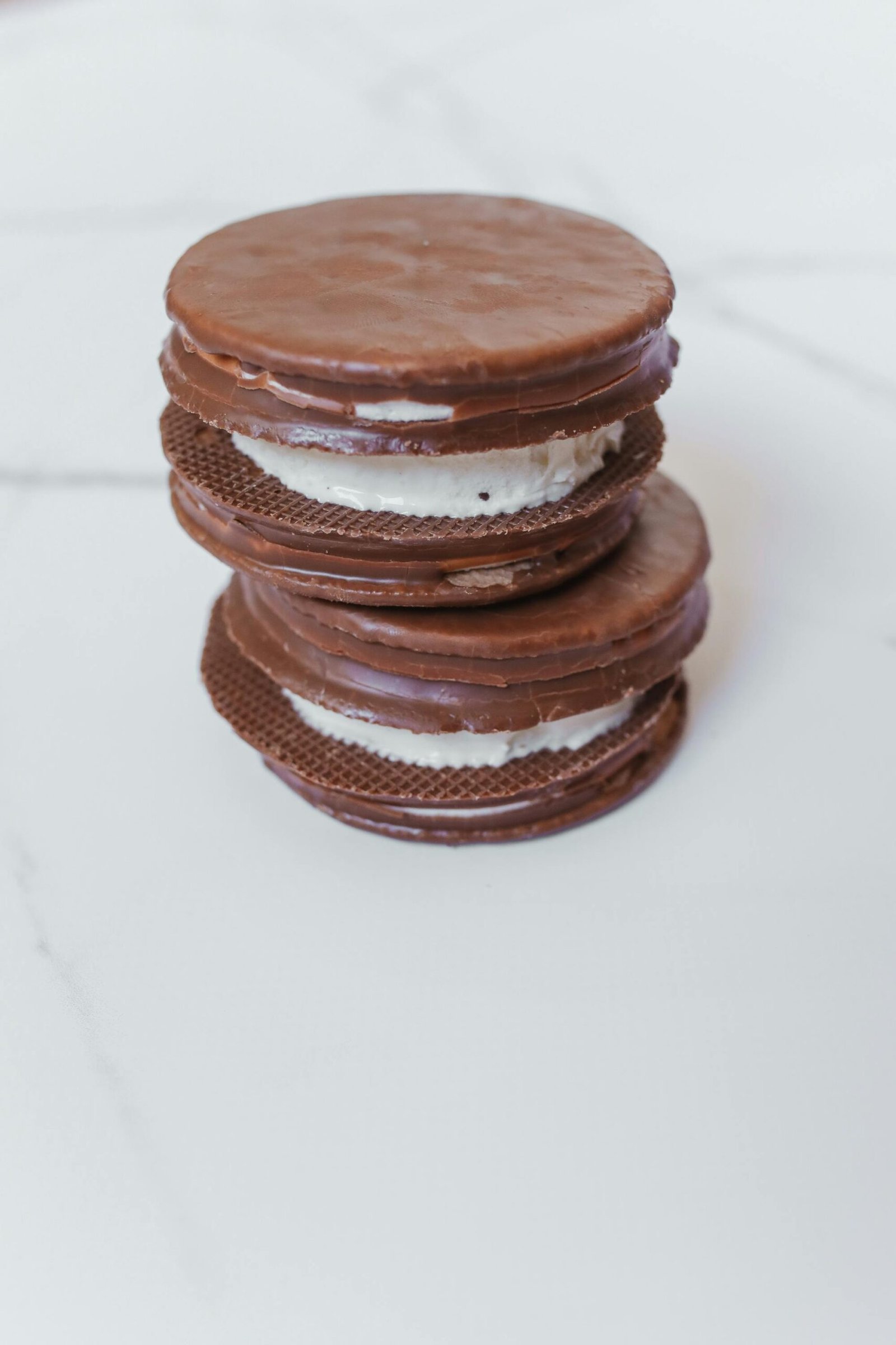 A tempting stack of homemade chocolate cookie sandwiches filled with cream.