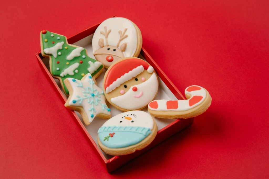 High angle of small box with traditional Christmas biscuits covered with colourful icing on red background Sugar Cookie Icing Recipe