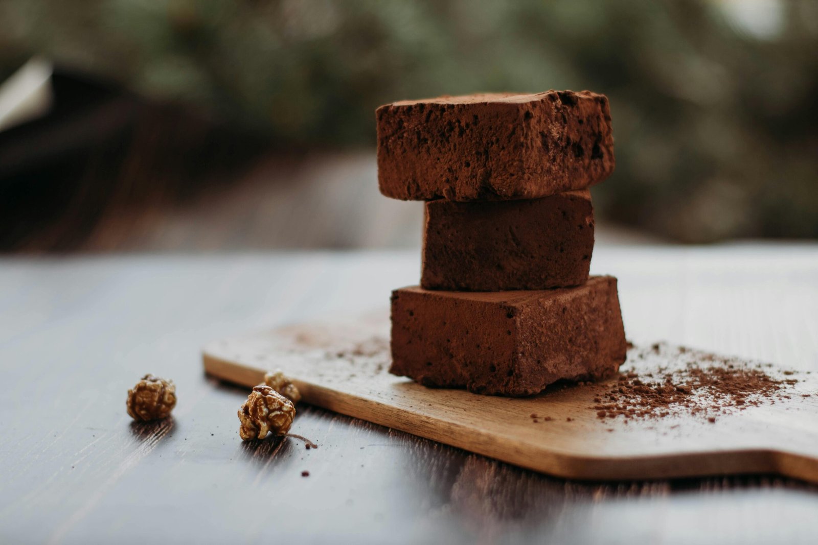 Close-up of rich chocolate brownies stacked on a wooden board, perfect for dessert lovers.