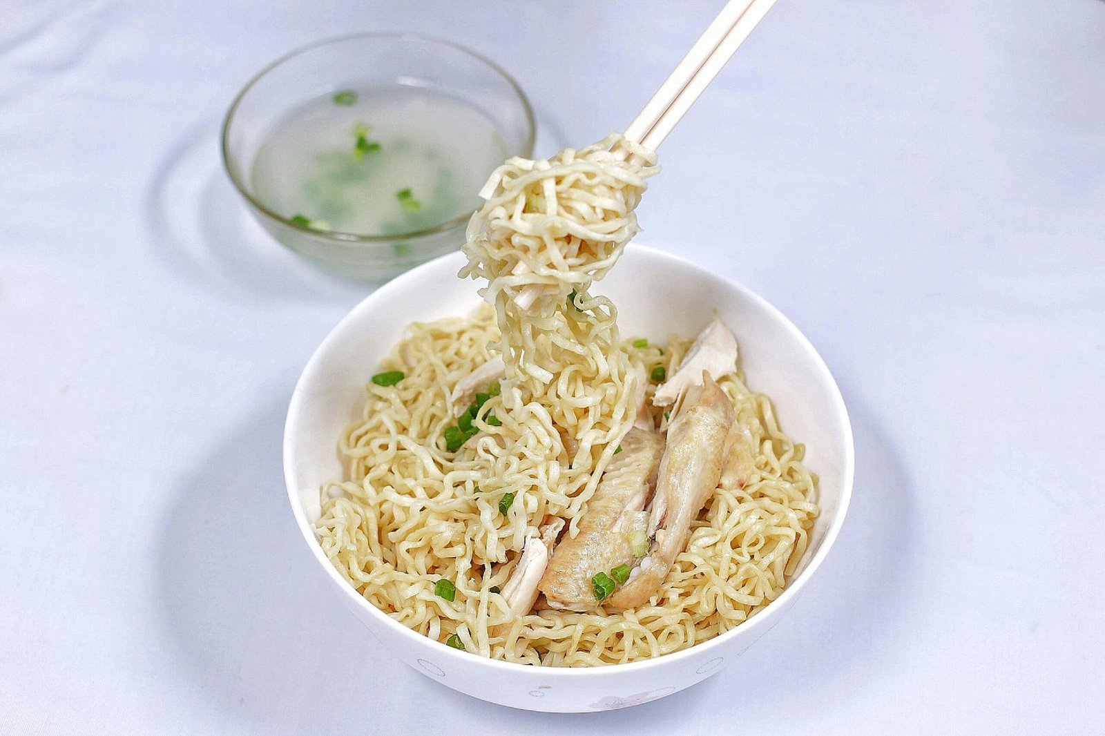 Tasty Indonesian chicken noodle dish with broth, showcasing vibrant flavors and textures.