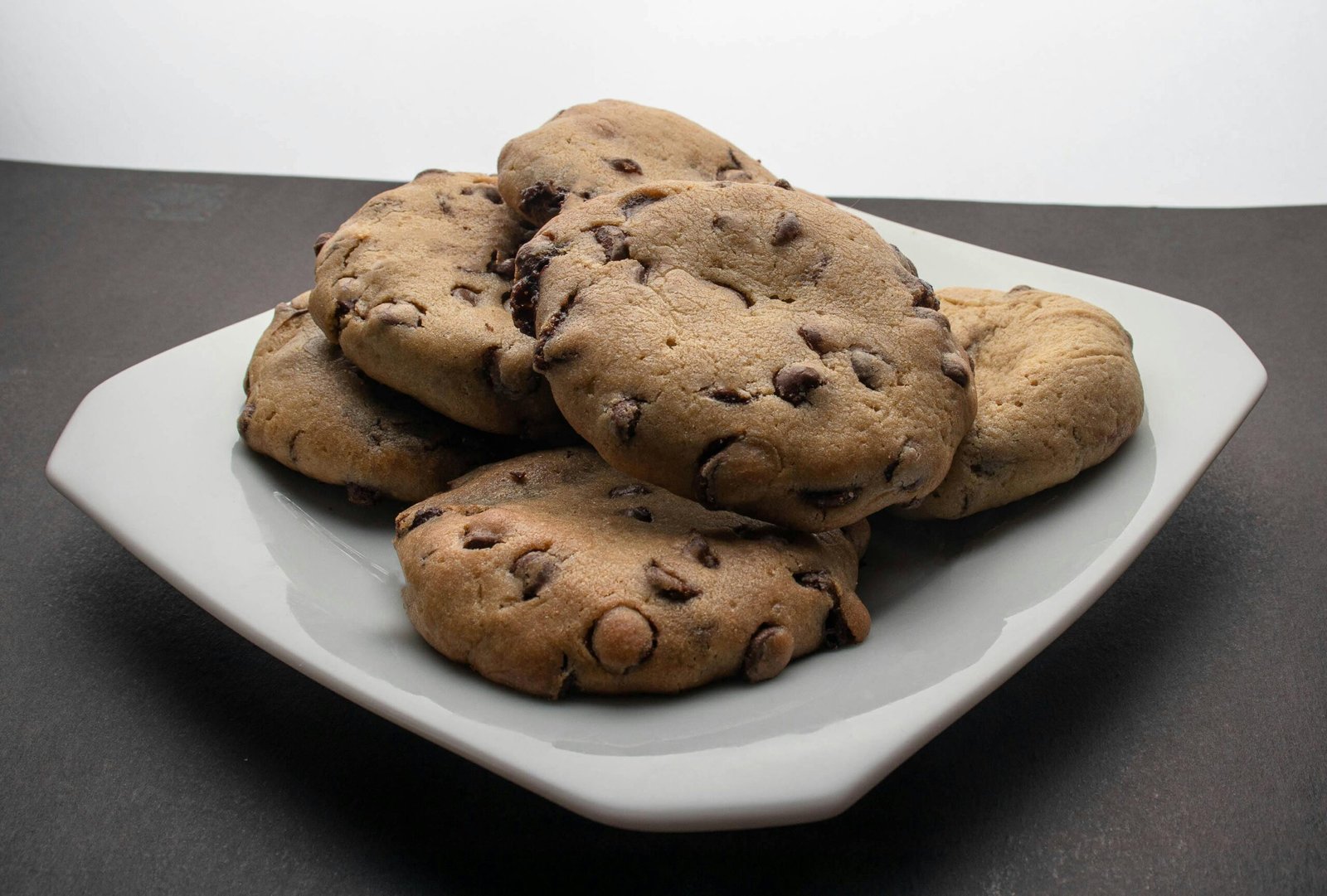 Close-up of freshly baked chocolate chip cookies on a plate, perfect for dessert.