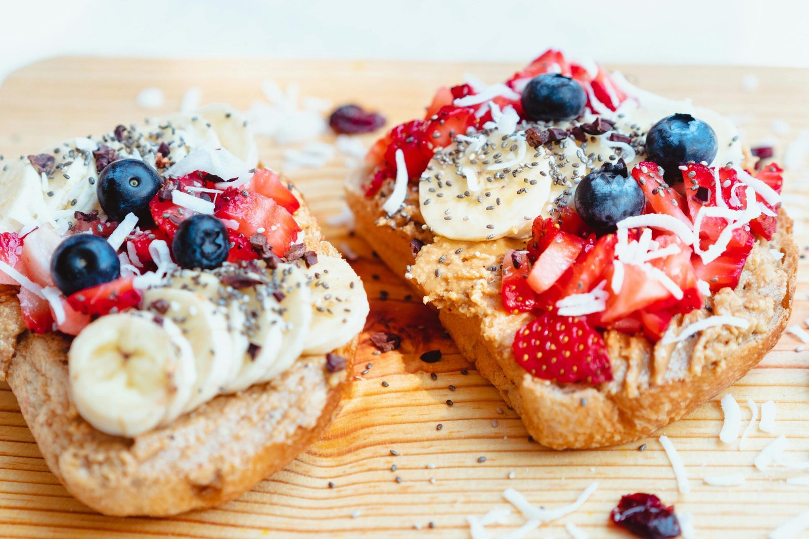 Close-up of fruit and peanut butter topped toast on a wooden board, perfect for healthy eating.