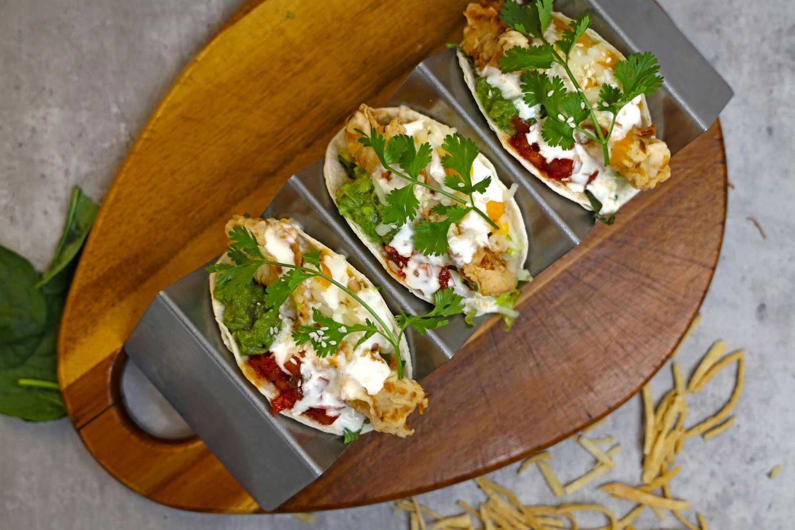 Mouth-watering homemade tacos topped with fresh ingredients on a rustic board.