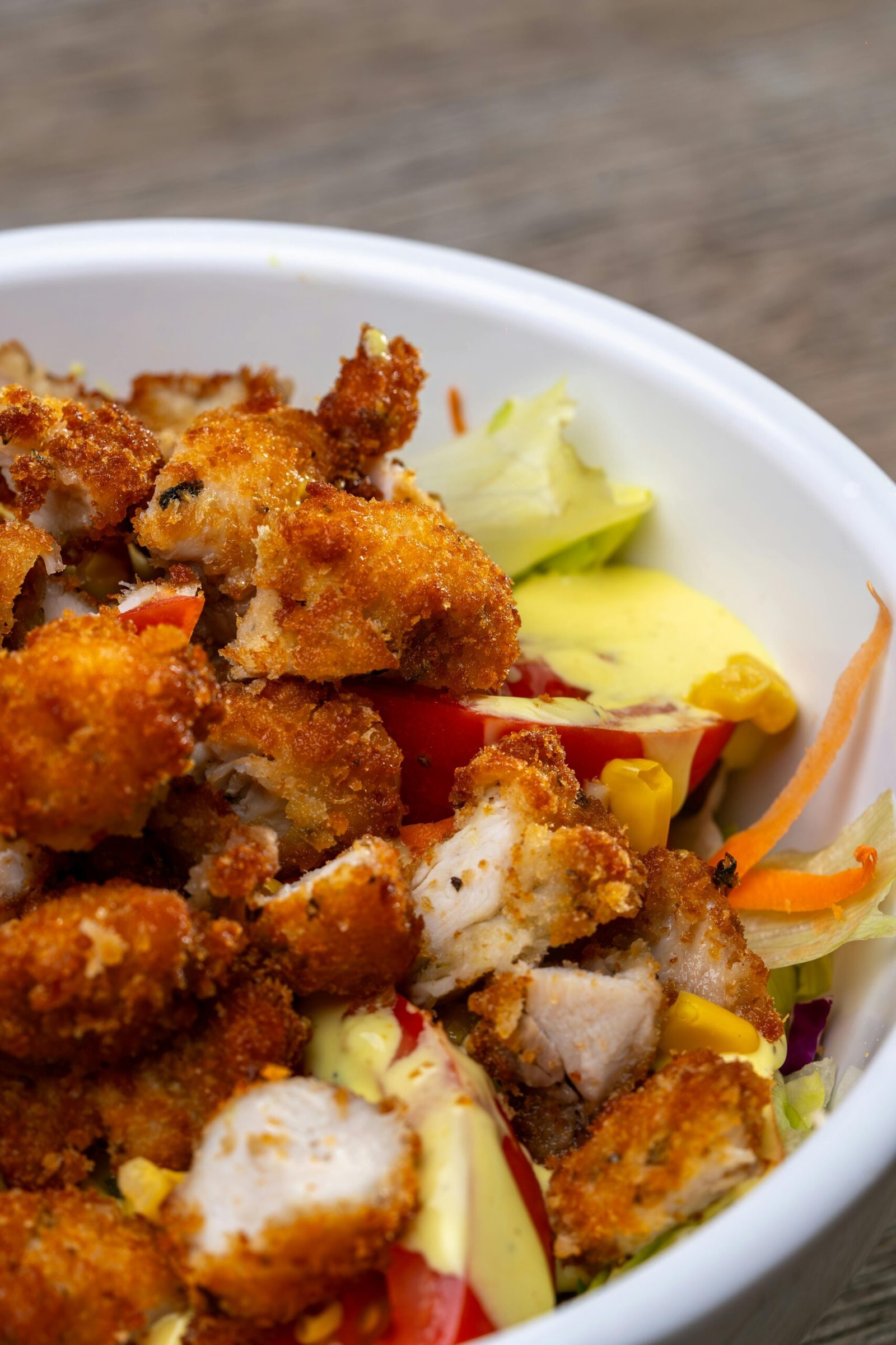 A vibrant close-up view of a crispy chicken salad with fresh vegetables.