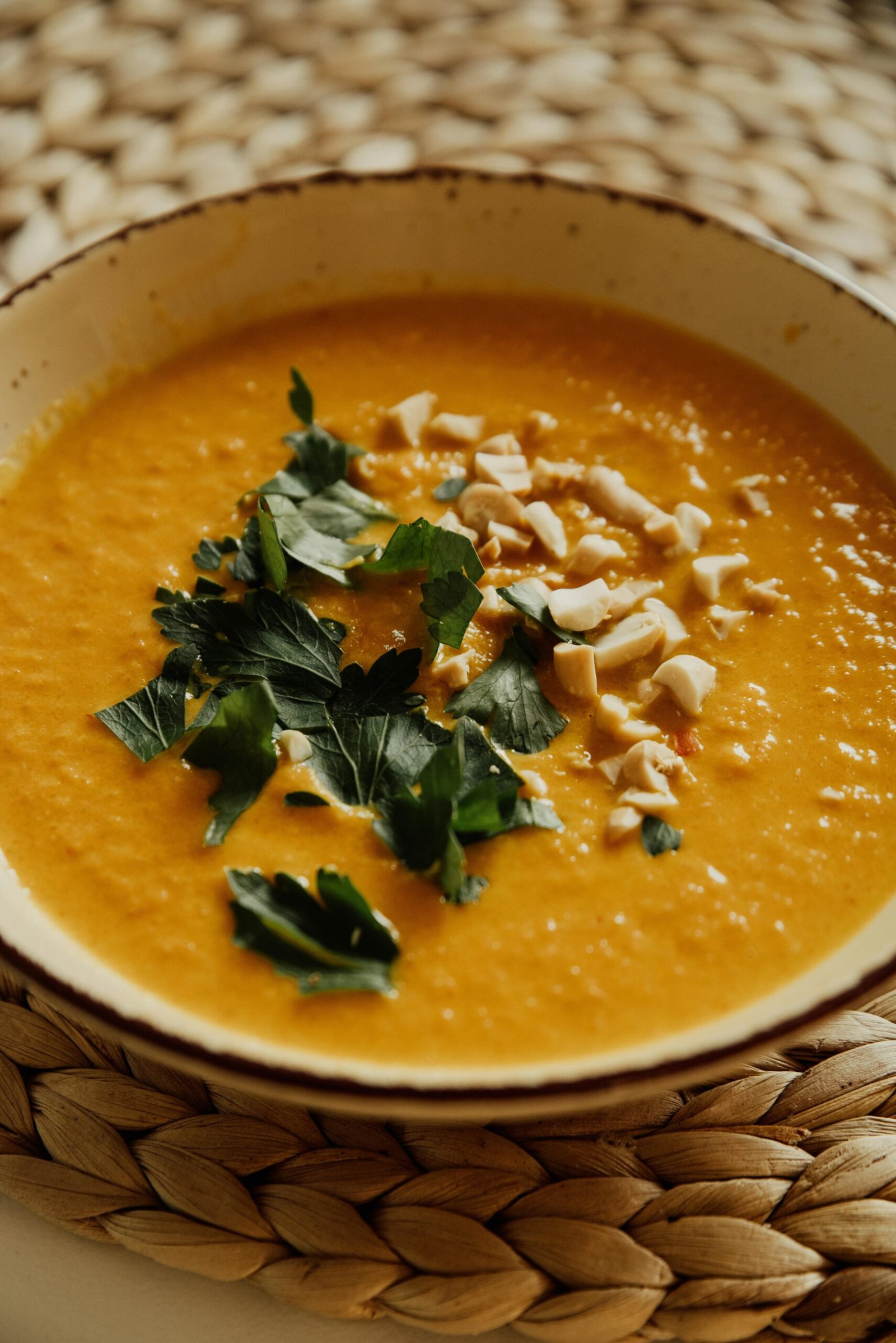 Warm and inviting pumpkin soup garnished with herbs and nuts, perfect for a cozy meal.