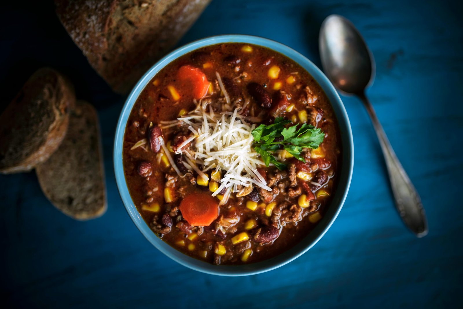 Delicious homemade beef chili served with fresh bread on a rustic table for a cozy meal.