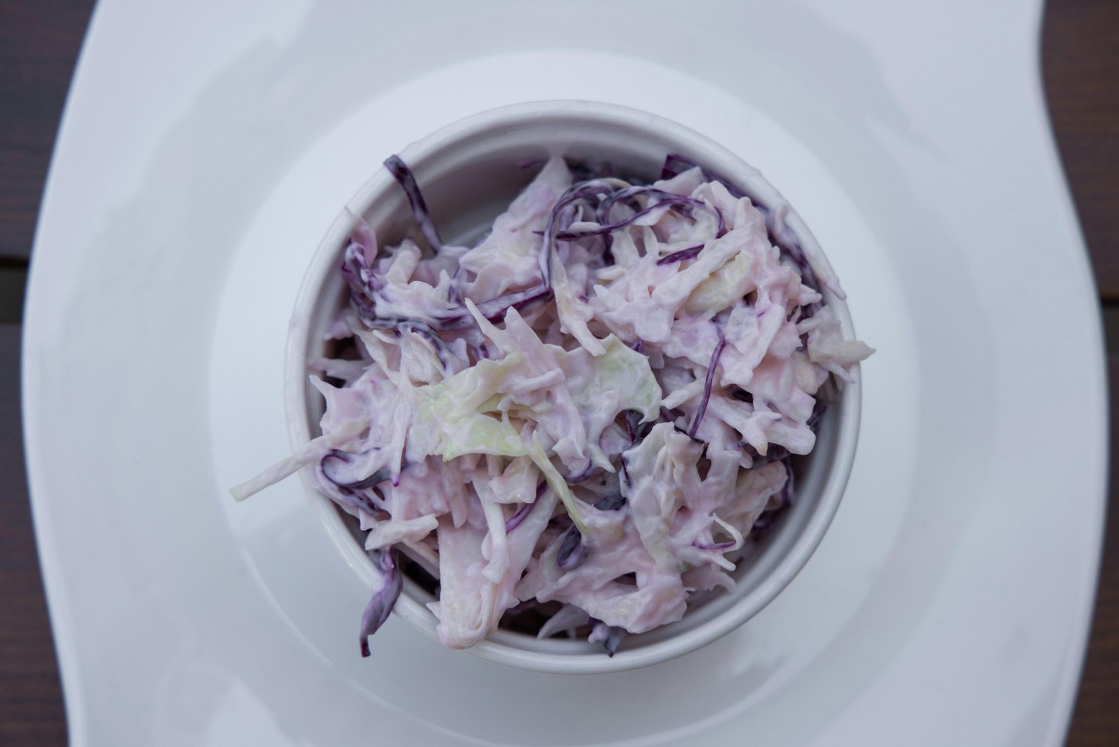 Delicious creamy coleslaw made with red cabbage in a white bowl, perfect for healthy, vegetarian meals.