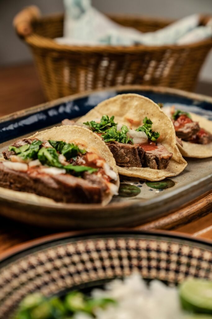 Three mouth-watering Mexican tacos served on a platter with fresh cilantro and onions. easy ground beef tacos recipe